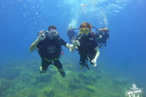 Open Water Diver Student übt Unterwasser-Fertigkeiten mit Tauchlehrer in klarem tropischen Wasser